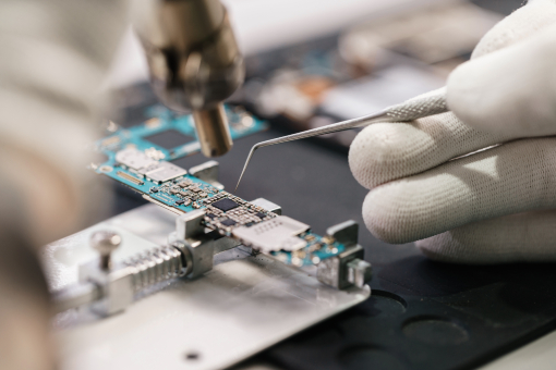 Skilled technician carefully soldering electronic components on a circuit board