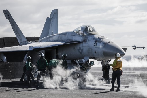 Fighter jet on the runway undergoing a thorough inspection by professionals